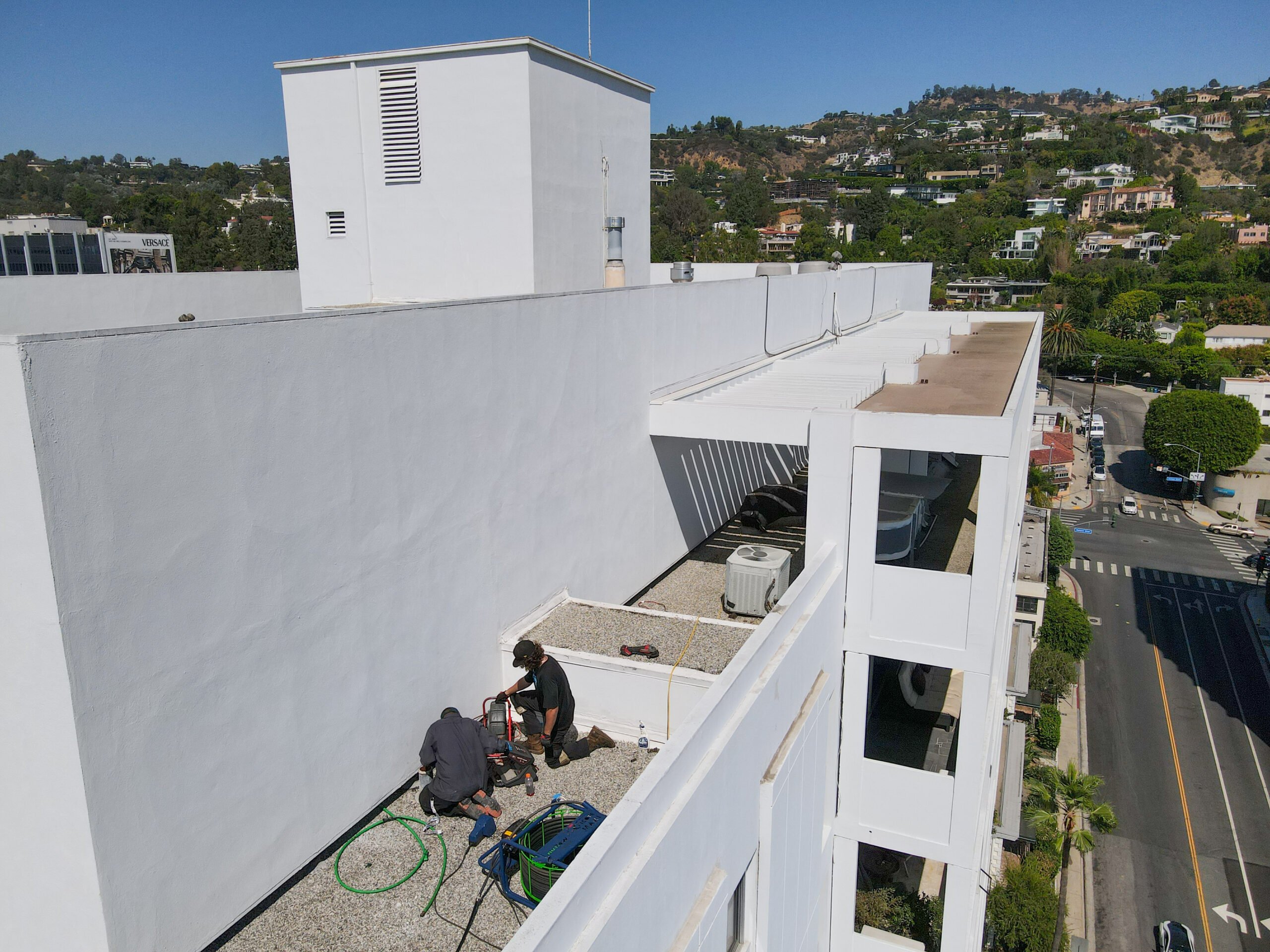 PRS technicians performing roof drain pipe repair in California