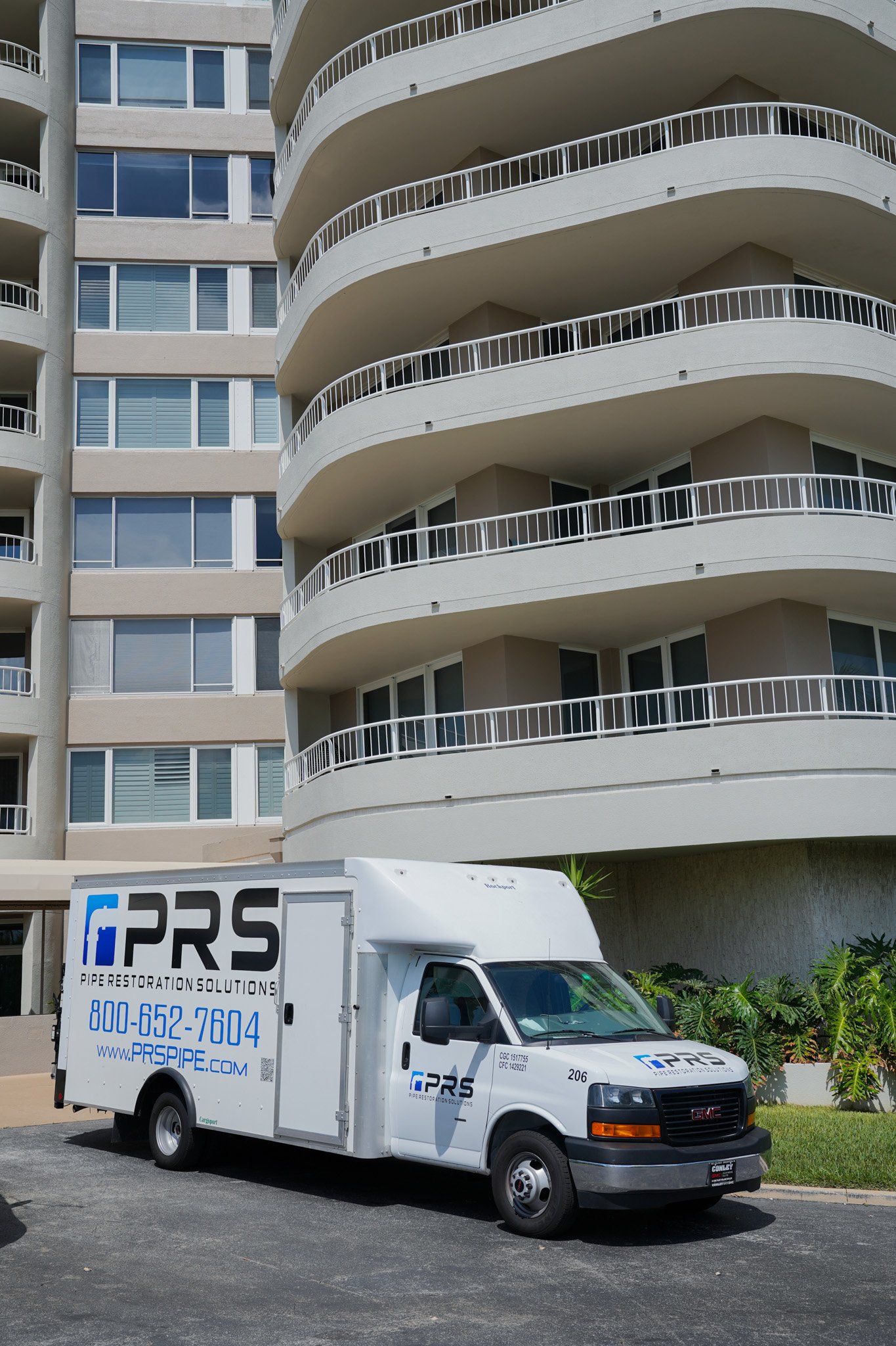 PRS truck parked in front of a condo for roof drain pipe repair